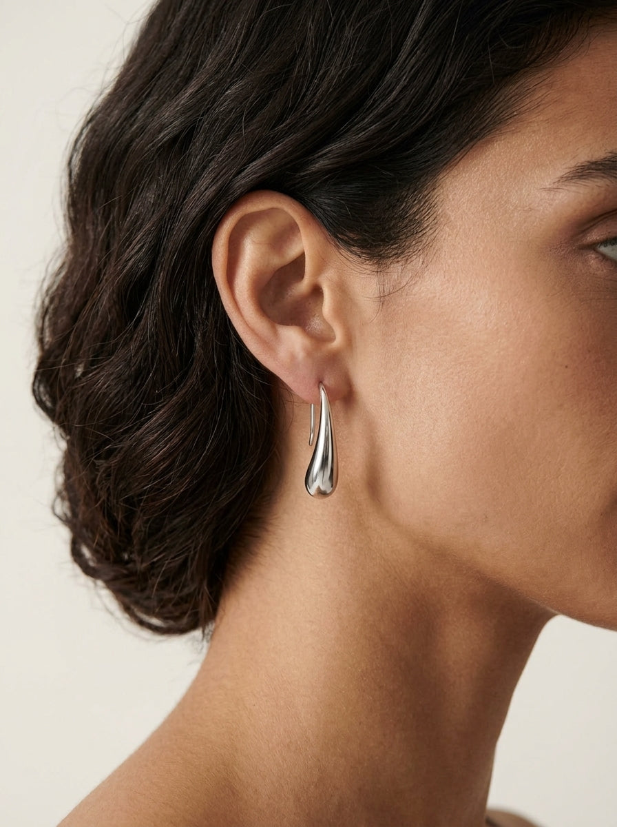 Woman wearing Lova silver hoop earrings