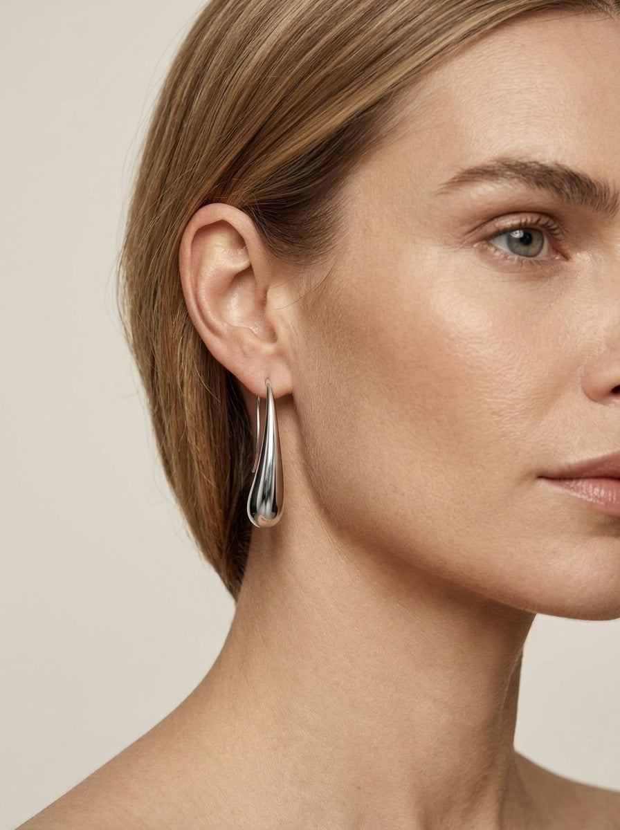 Woman wearing Lova silver teardrop earrings