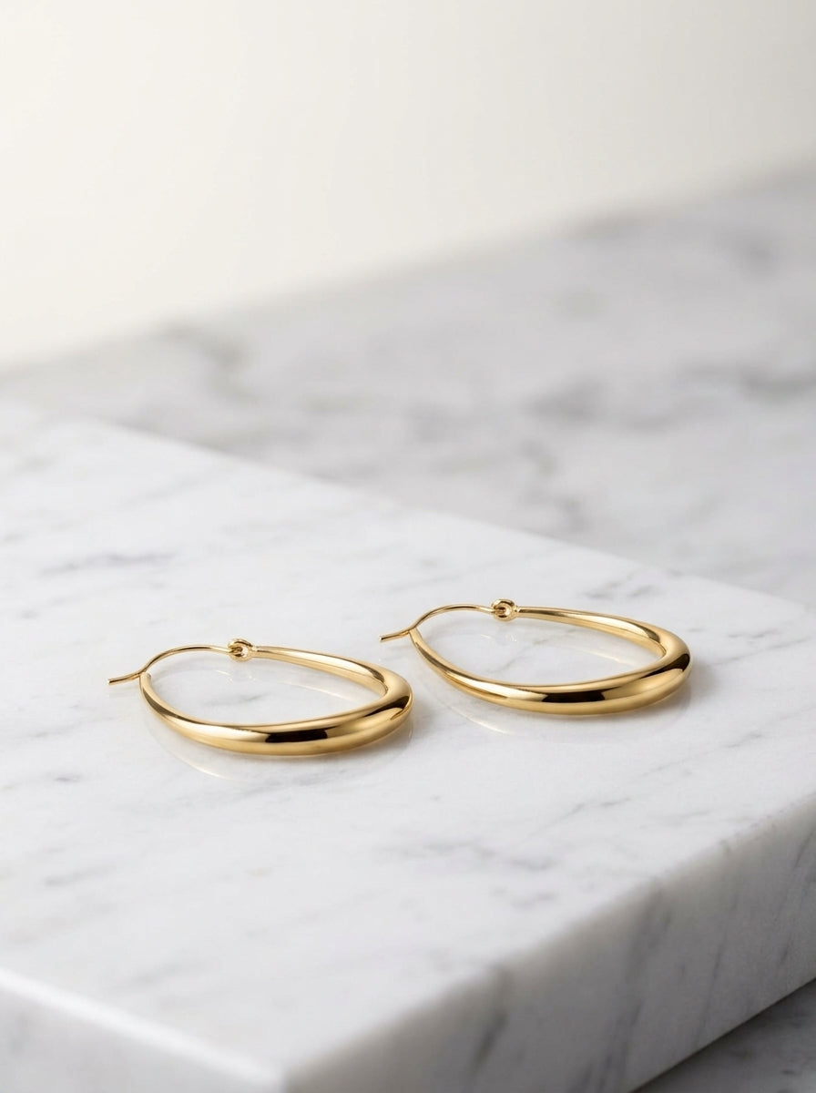 Maia gold teardrop hoops on a countertop