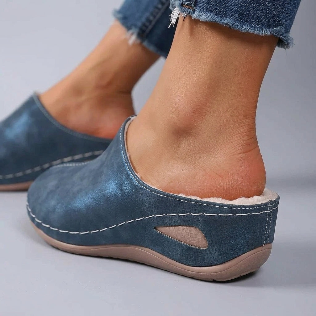 Woman wearing Rosie slip-on slippers in blue
